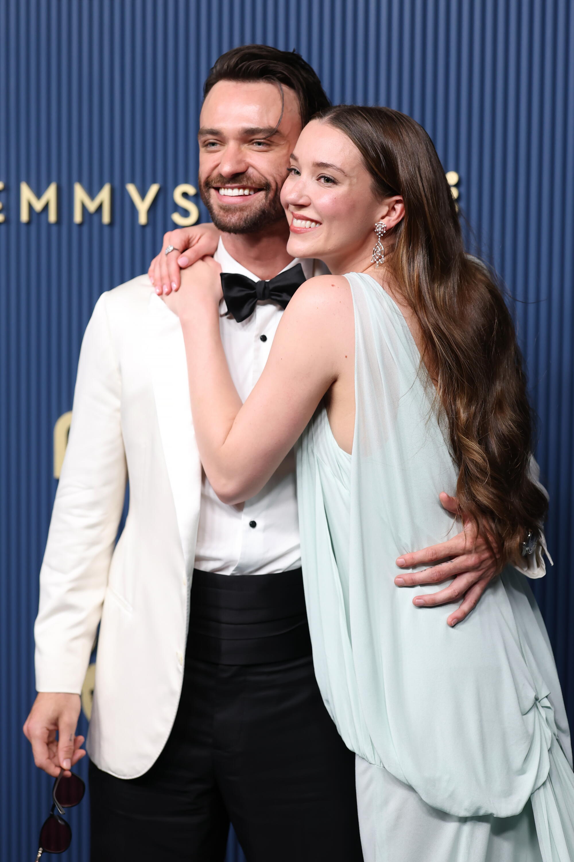 Thomas Doherty and Nicole Brydon Bloom hug on the Emmys blue carpet. 
