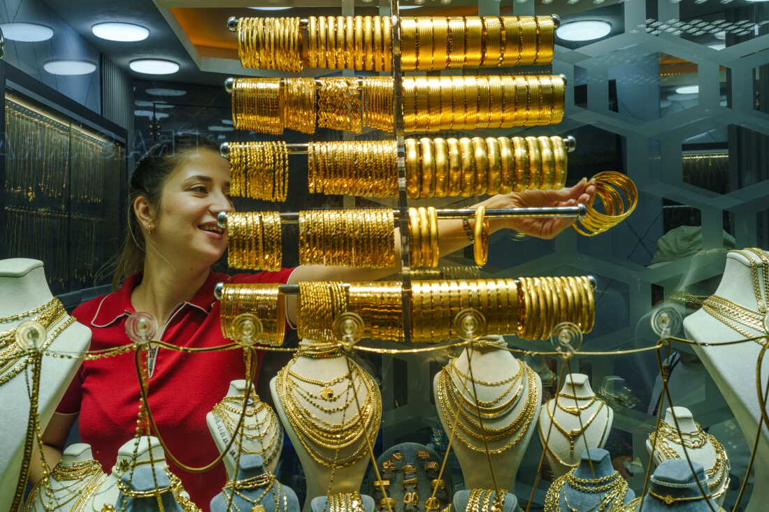 A female jeweler takes gold bracelets from a display case at the Grand Bazaar to show them to customers in Istanbul, Turkey, on Aug. 20, 2026.