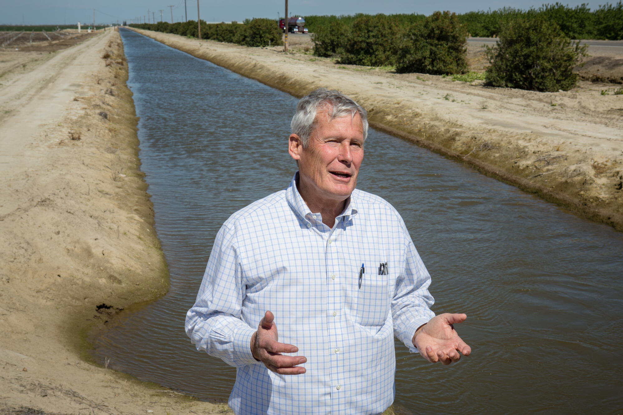 Don Cameron stands next to an irrigation canal where his farm draws water from the Kings River.