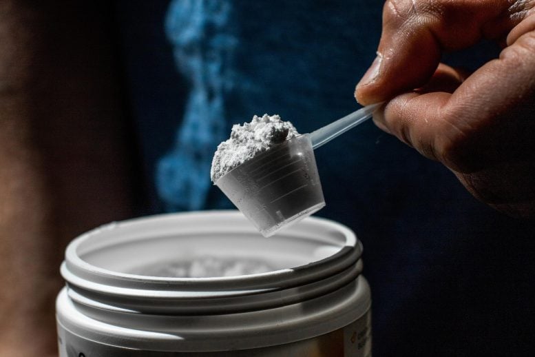 Man Scooping Sport Supplement Creatine Powder