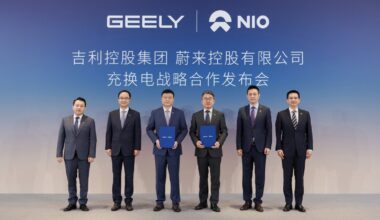 Geely and Nio representatives pose with agreement folders at a signing ceremony for their charging and battery swap partnership.