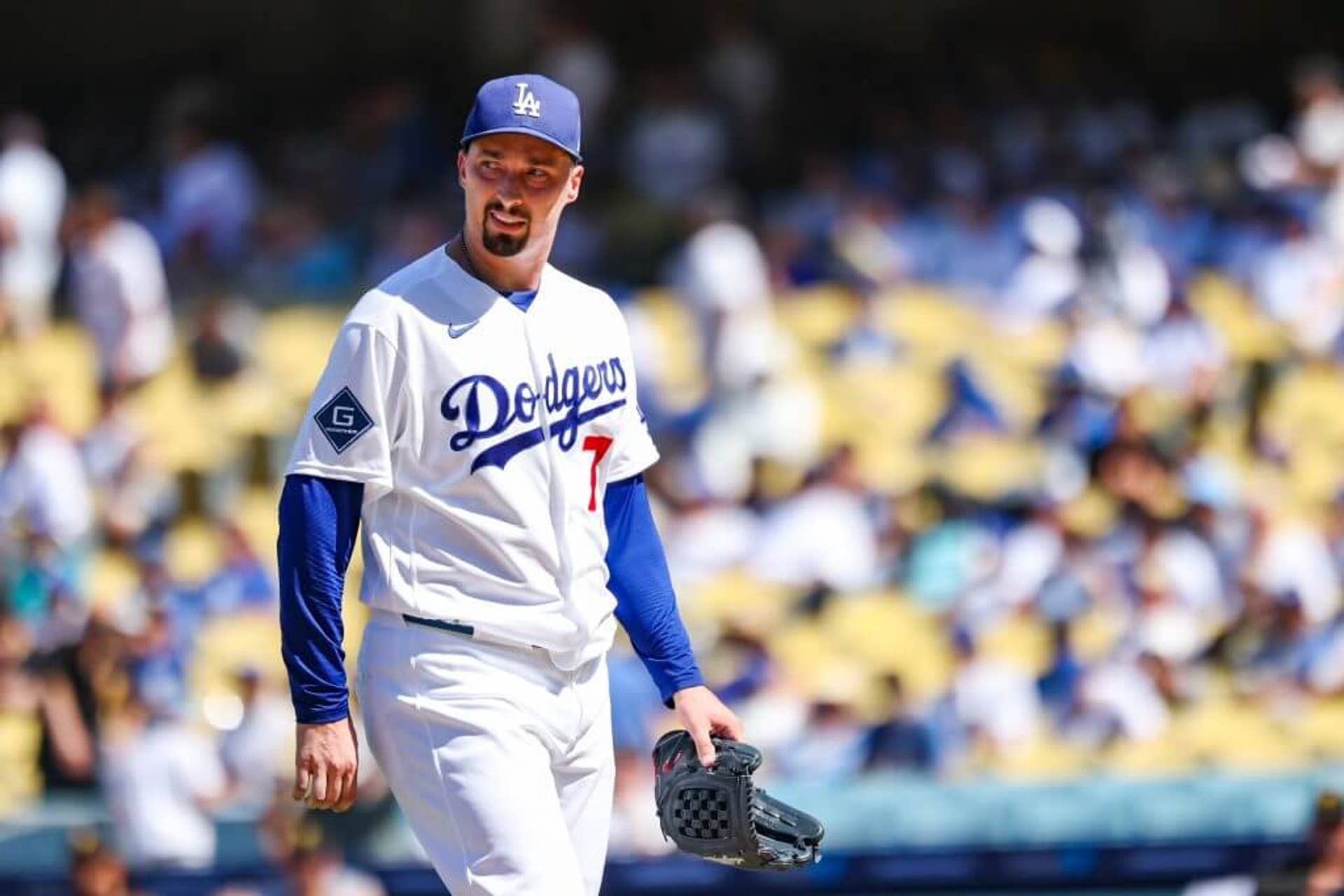 Los Angeles Dodgers pitcher Blake Snell looks off to the side with his arms down at this sides, carrying his glove, as he completes an inning.