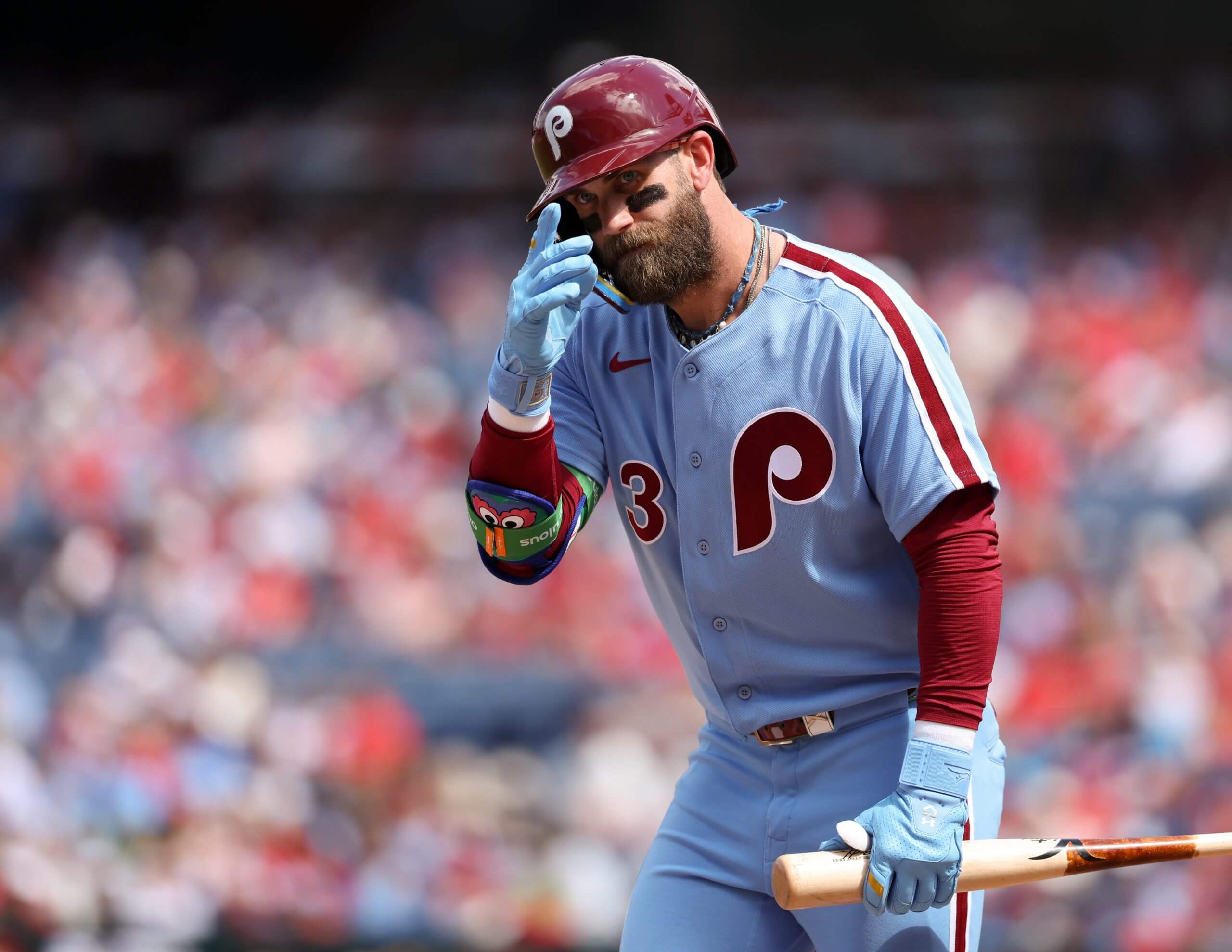 Bryce Harper tips his batting helmet toward the Astros dugout as he walks away from the plate.