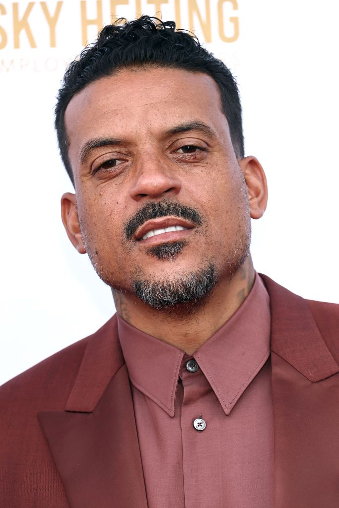 Matt Barnes wearing a reddish-brown suit jacket and matching collared shirt.