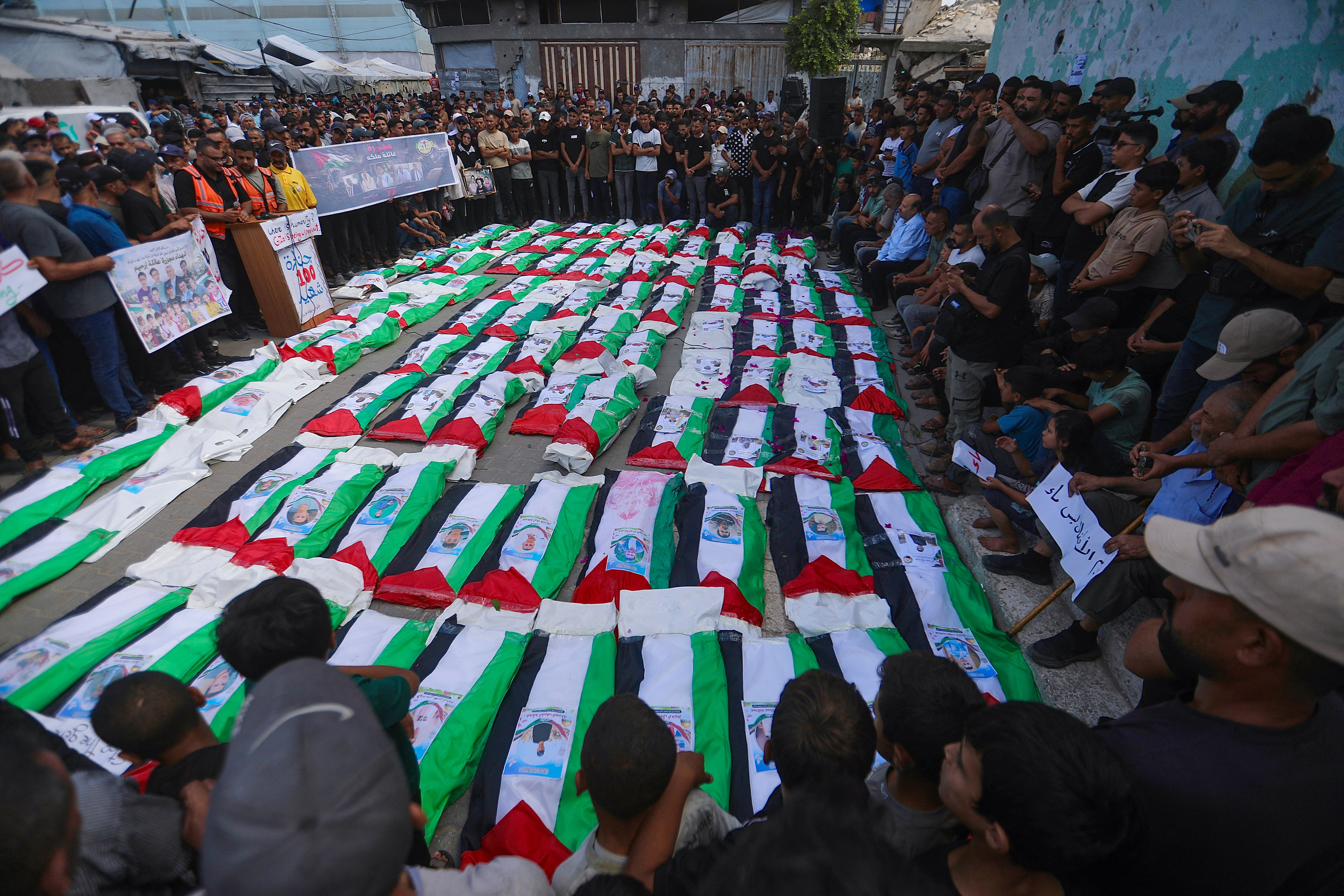 People gather around rows of bodies during a funeral ceremony in Zeitoun neighborhood of Gaza City, Gaza