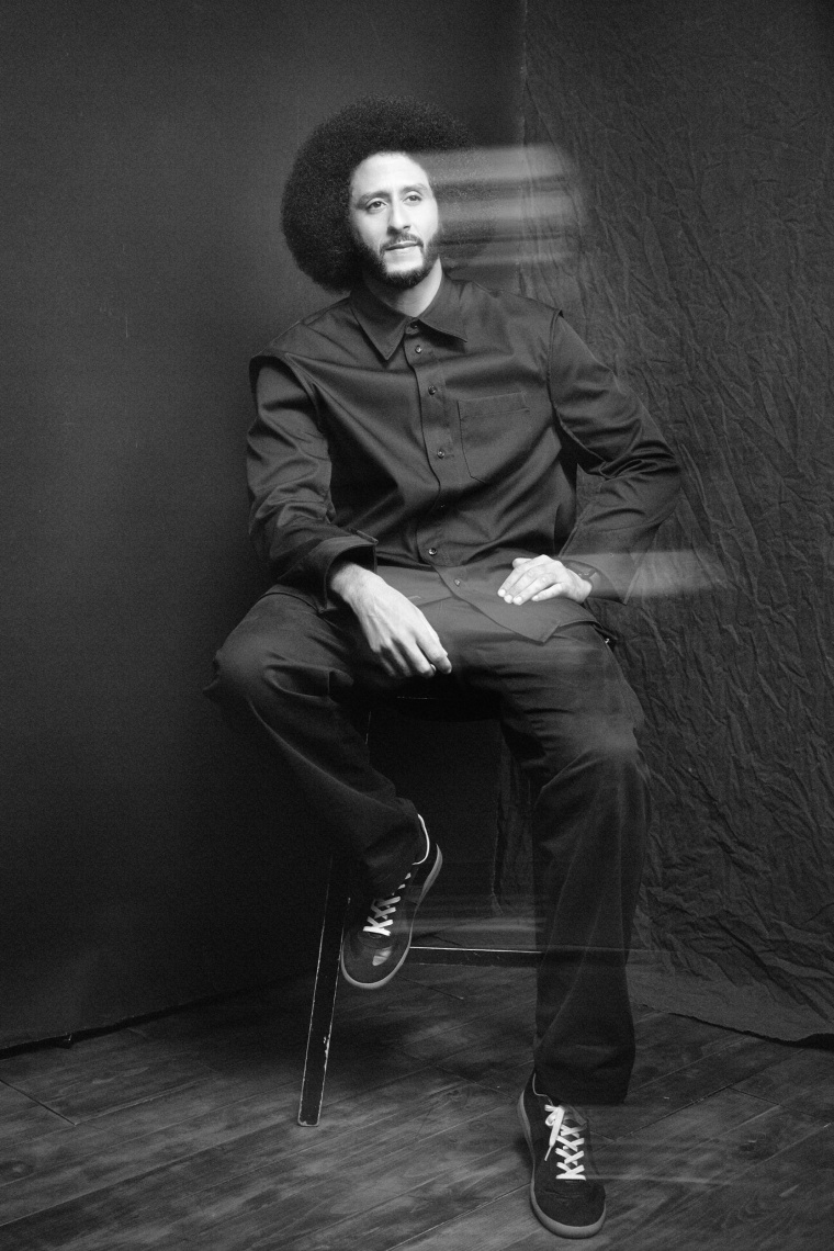 Colin Kaepernick looks at the camera during a portrait session; his hands and face have a motion blur.