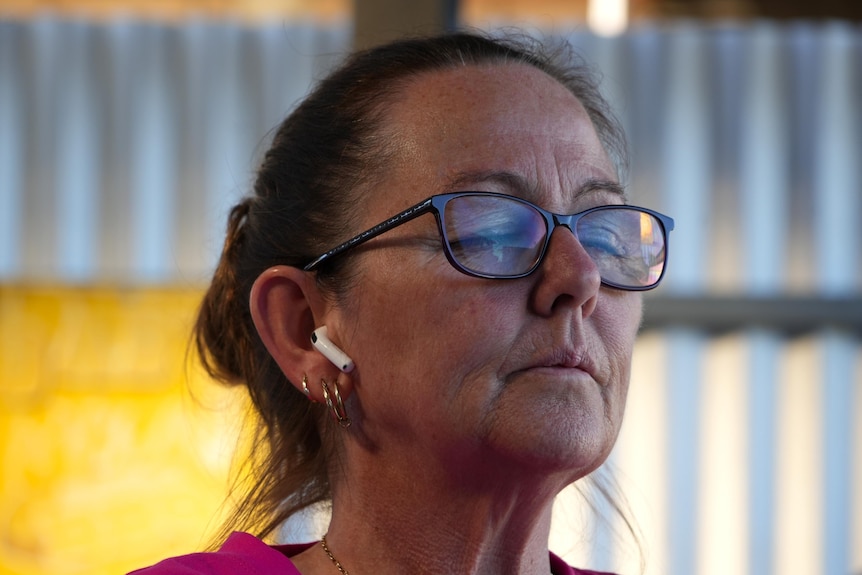 Stacey is seen meditating. She is wearing glasses