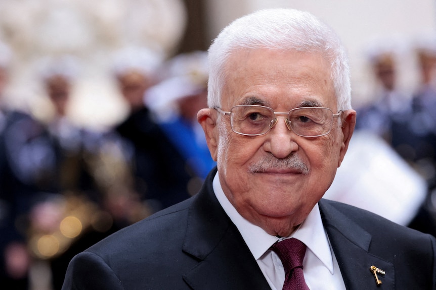 A headshot of Mahmoud Abbas wearing a black suit against a blurred background.