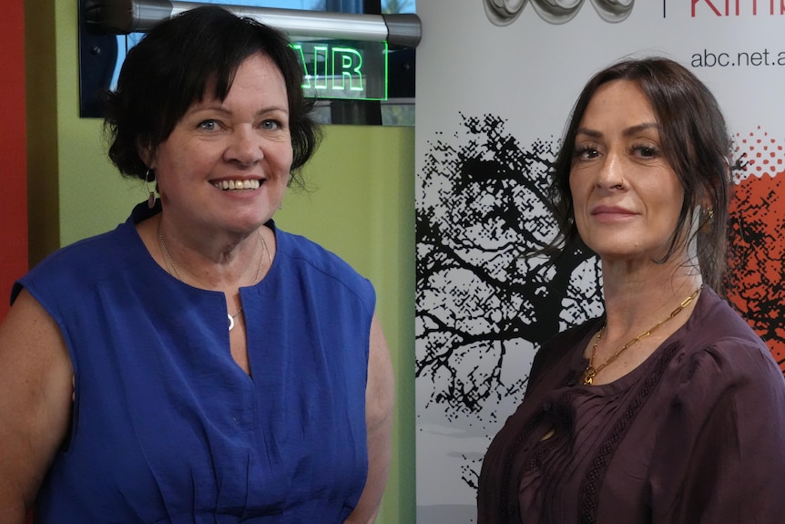 Two women standing in radio studio looking at camera