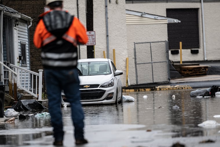 A worker assess flooding damage in Collingdale after a 2023 storm. Delaware County is installing flood gauges to help gather data and better prepare for increasingly intense precipitation events.