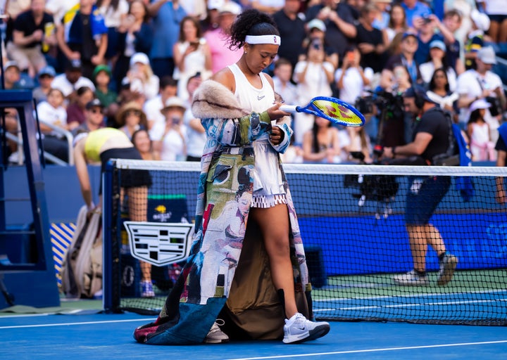 Japan’s Naomi Osaka walks onto the court in an abstract, patchwork-style coat ahead of her fourth-round match against Kazakhstan’s Elena Rybakina on Monday at the U.S. Open. 