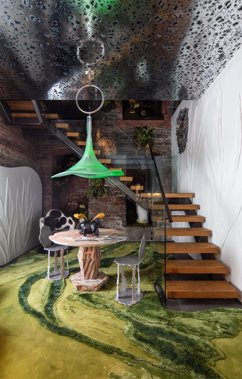 Modern interior design featuring unique furniture, green carpet, and staircase in a creatively styled space.