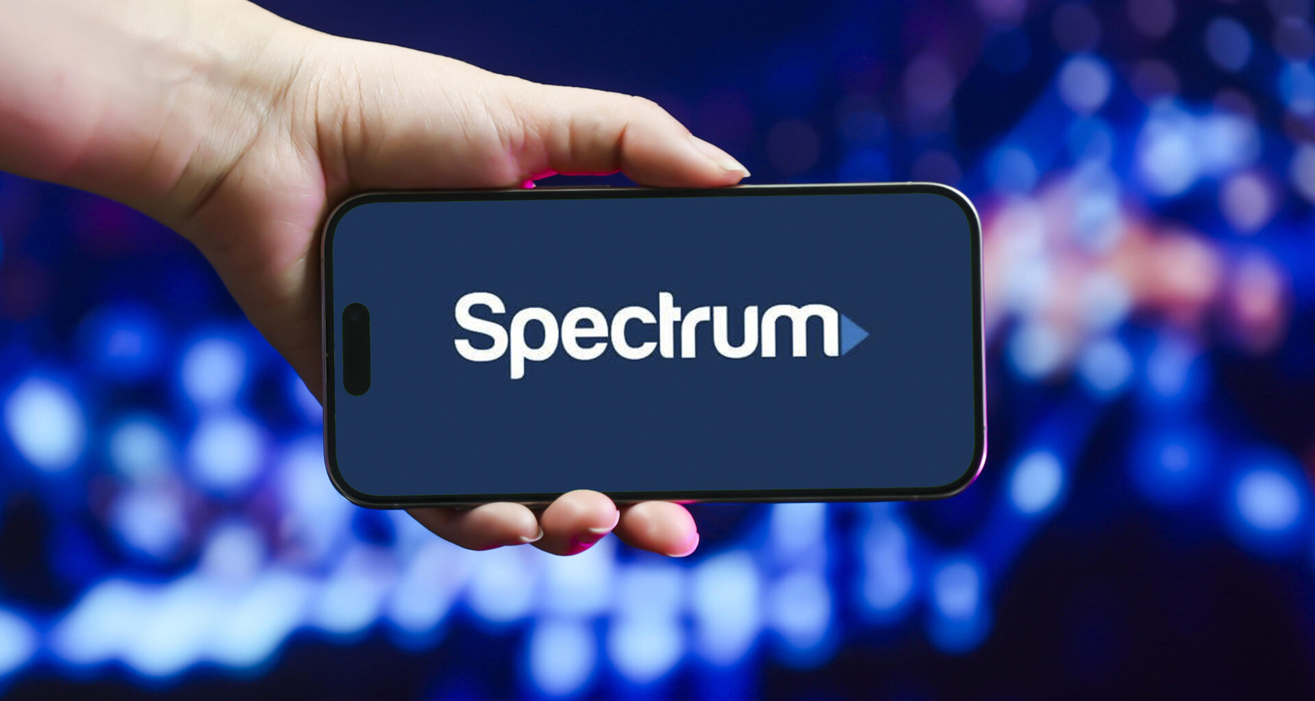 hand holding phone with Spectrum logo on screen