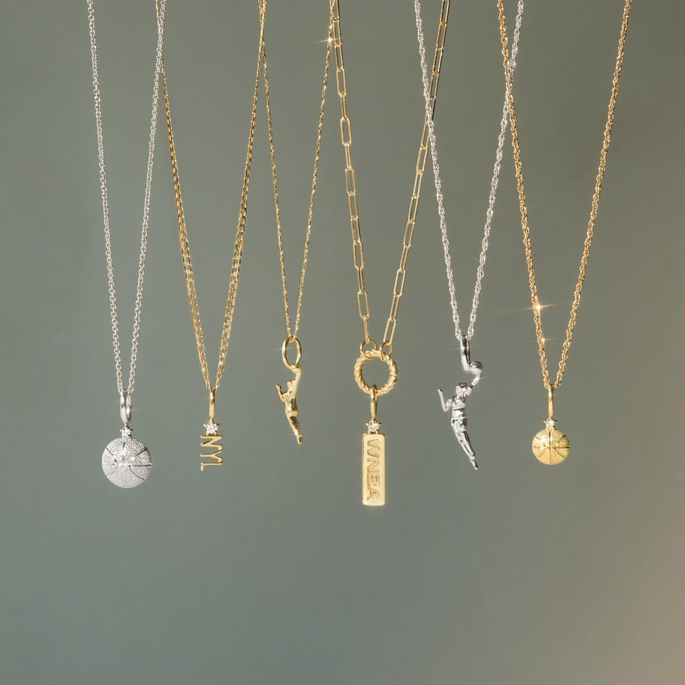 Assorted necklaces featuring various pendants hanging against a neutral background. Assorted necklaces featuring various pendants hanging against a neutral background.