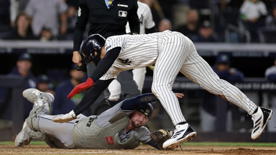 New York Yankees' George Lombard Jr. avoids a tag from Tampa Bay Rays catcher Liam Hicks to score a run during the seventh inning of a baseball game Thursday, Sept. 24, 2026, in New York. (AP Photo/Adam Hunger)