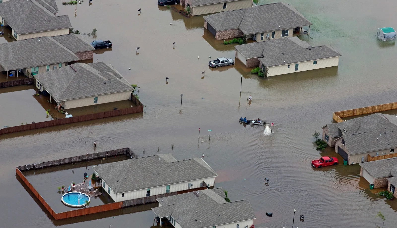 A boat motors between flooded homes after heavy rains inundating the region, in Hammond, La., on Aug. 13, 2016.