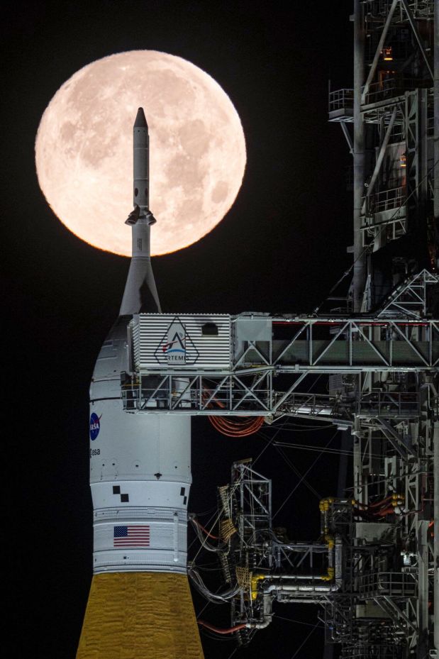 A full moon is seen shining over NASA’s SLS (Space Launch System) and Orion spacecraft, atop the mobile launcher in the early hours of Sunday, Feb. 1, 2026, at NASA’s Kennedy Space Center in Florida. (Sam Lott/NASA via AP)