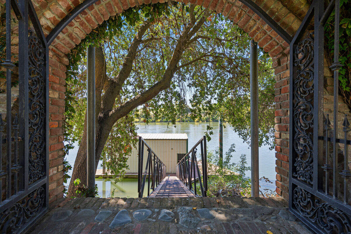 The estate’s private dock was designed with water-skiing in mind and includes an enclosed boathouse with a boat lift and roll-down door. The property sits near the apex of a bend in the Sacramento River.