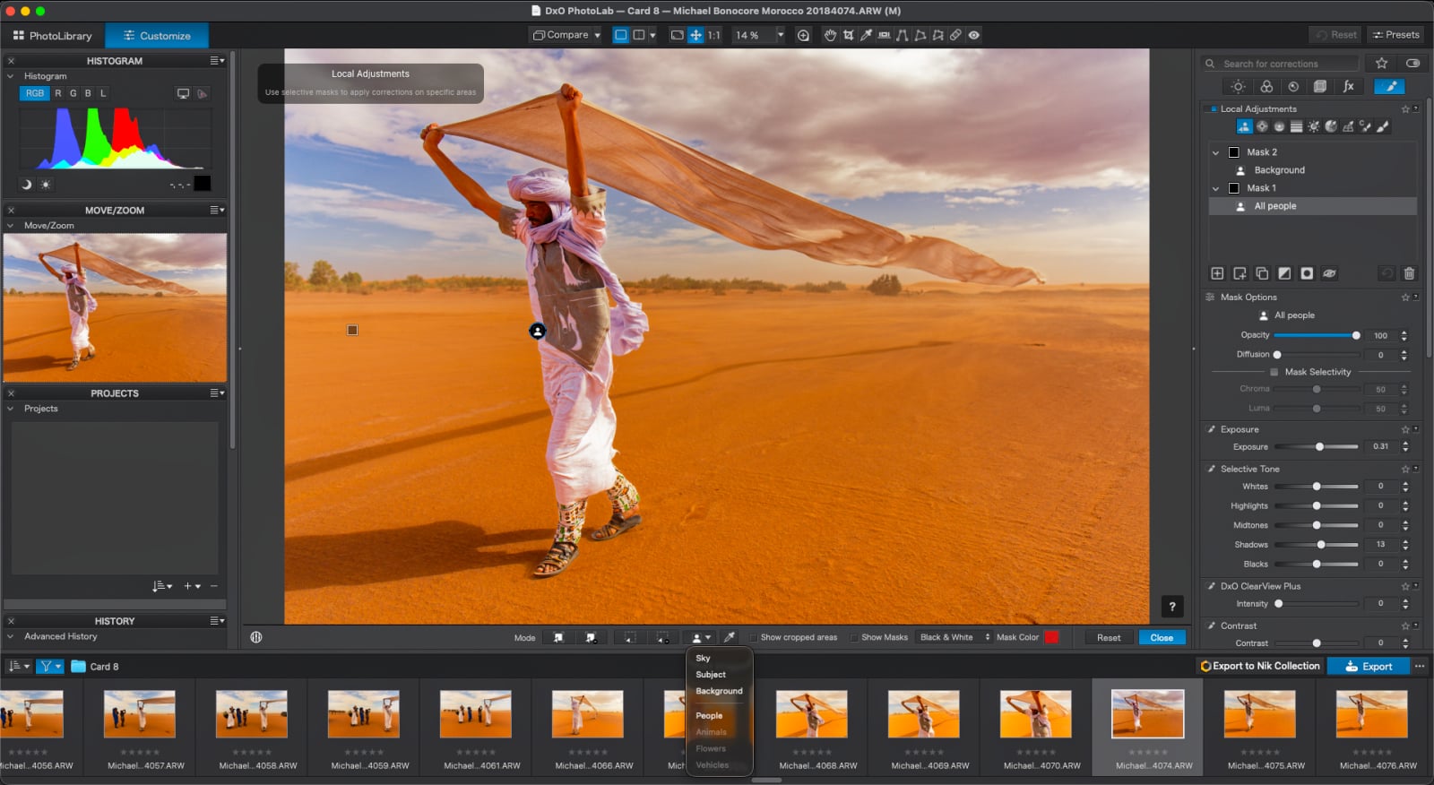 A man in traditional clothing walks across a desert landscape while holding a large, flowing fabric above his head, displayed within the DxO PhotoLab software interface.