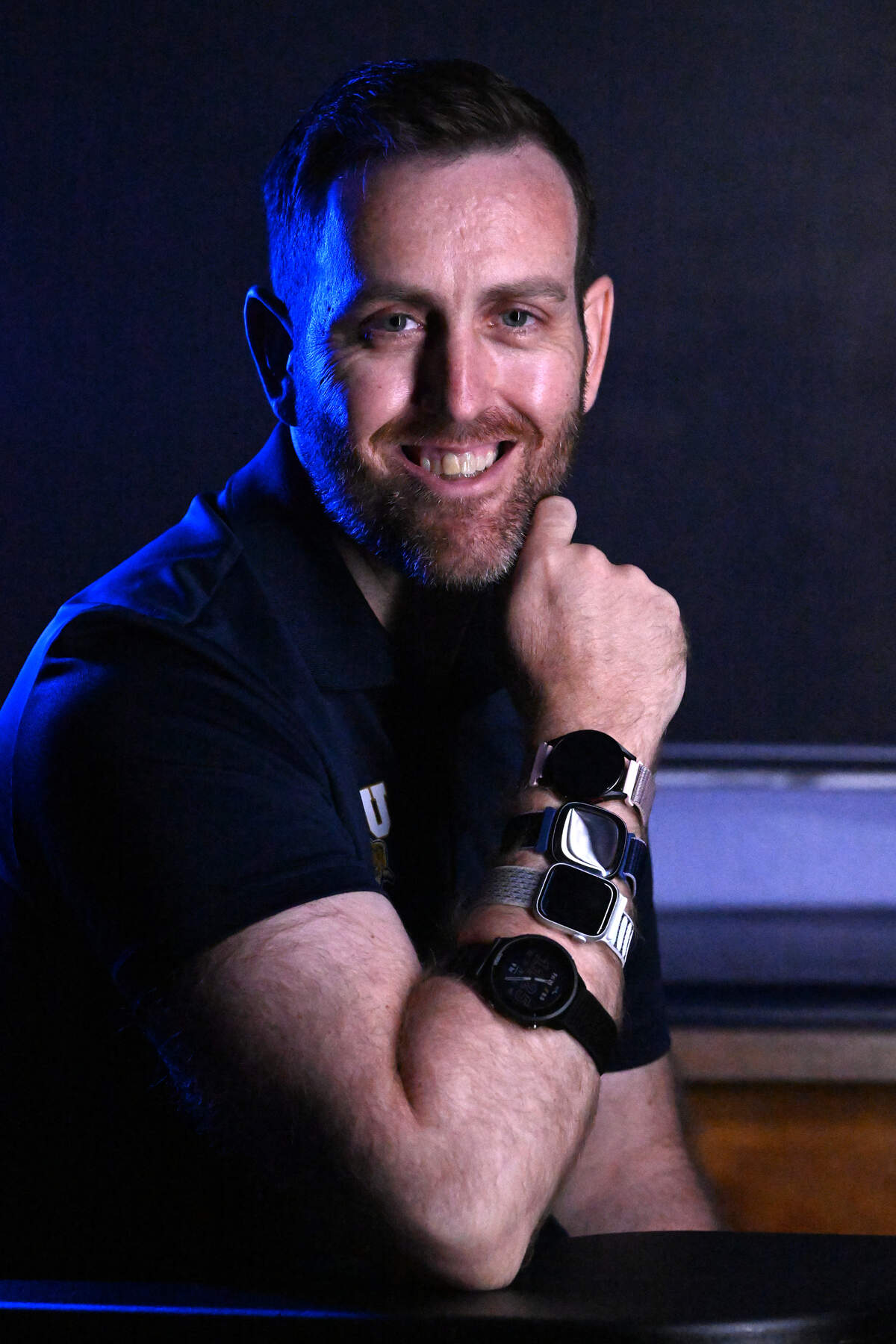 FIU researcher Jason Kostrna, associate professor of kinesiology and exercise science, wears the four smartwatches tested in his study — the Apple Watch Series 8, Fitbit Sense 2, Samsung Galaxy Watch 5 and Garmin Forerunner 955 — during a portrait session Friday, Aug. 21, 2026, at Florida International University in Miami. Kostrna led a study that found the devices overestimated calories burned during exercise, with errors increasing among participants with higher body-fat percentages.