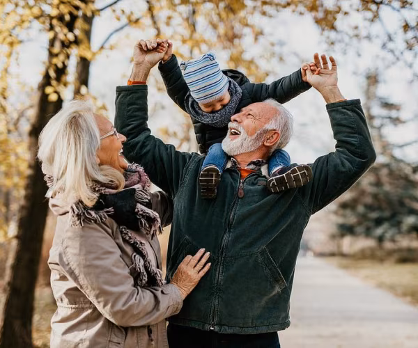 older couple walking in park with grandchild