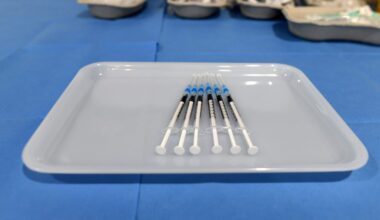 Hypodermic needles lined up in a tray.
