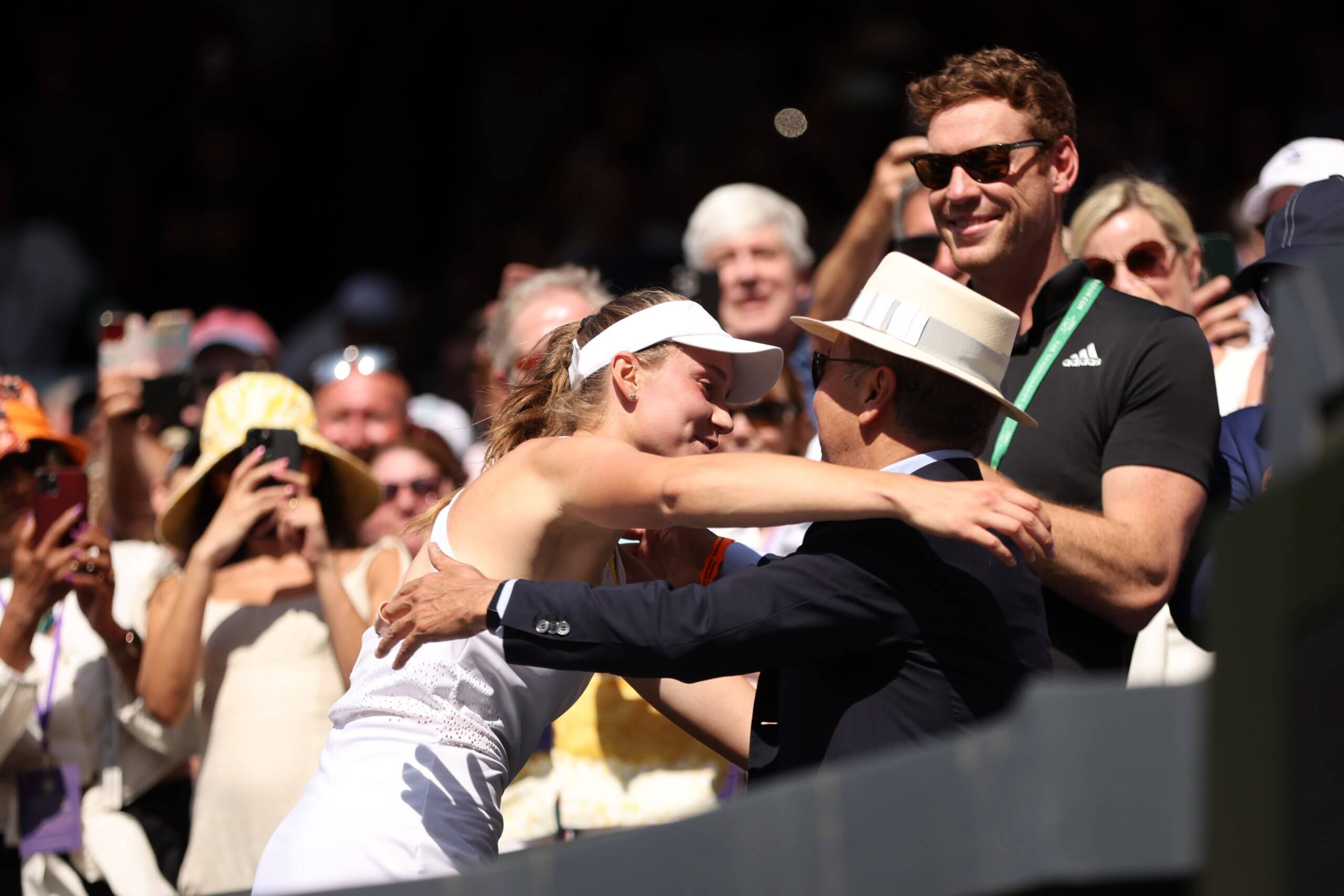Elena Rybakina hugs Bulat Utemuratov in a crowd.