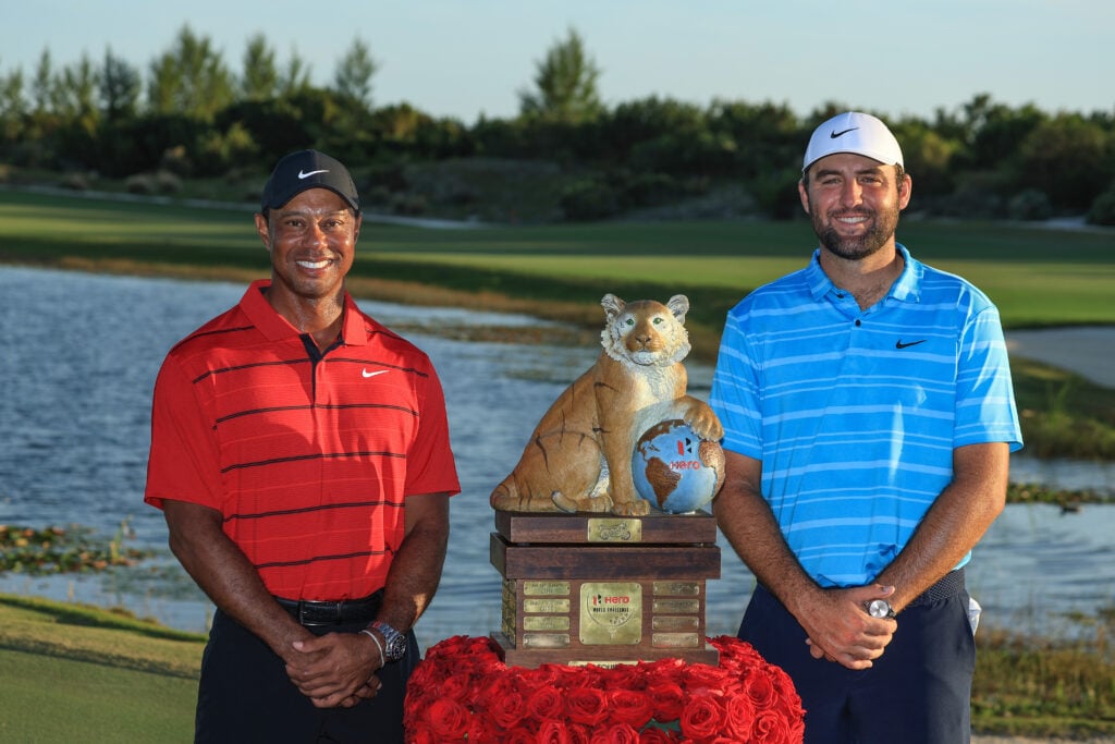 Scottie Scheffler is presented with the Hero World Challenge trophy by Tiger Woods