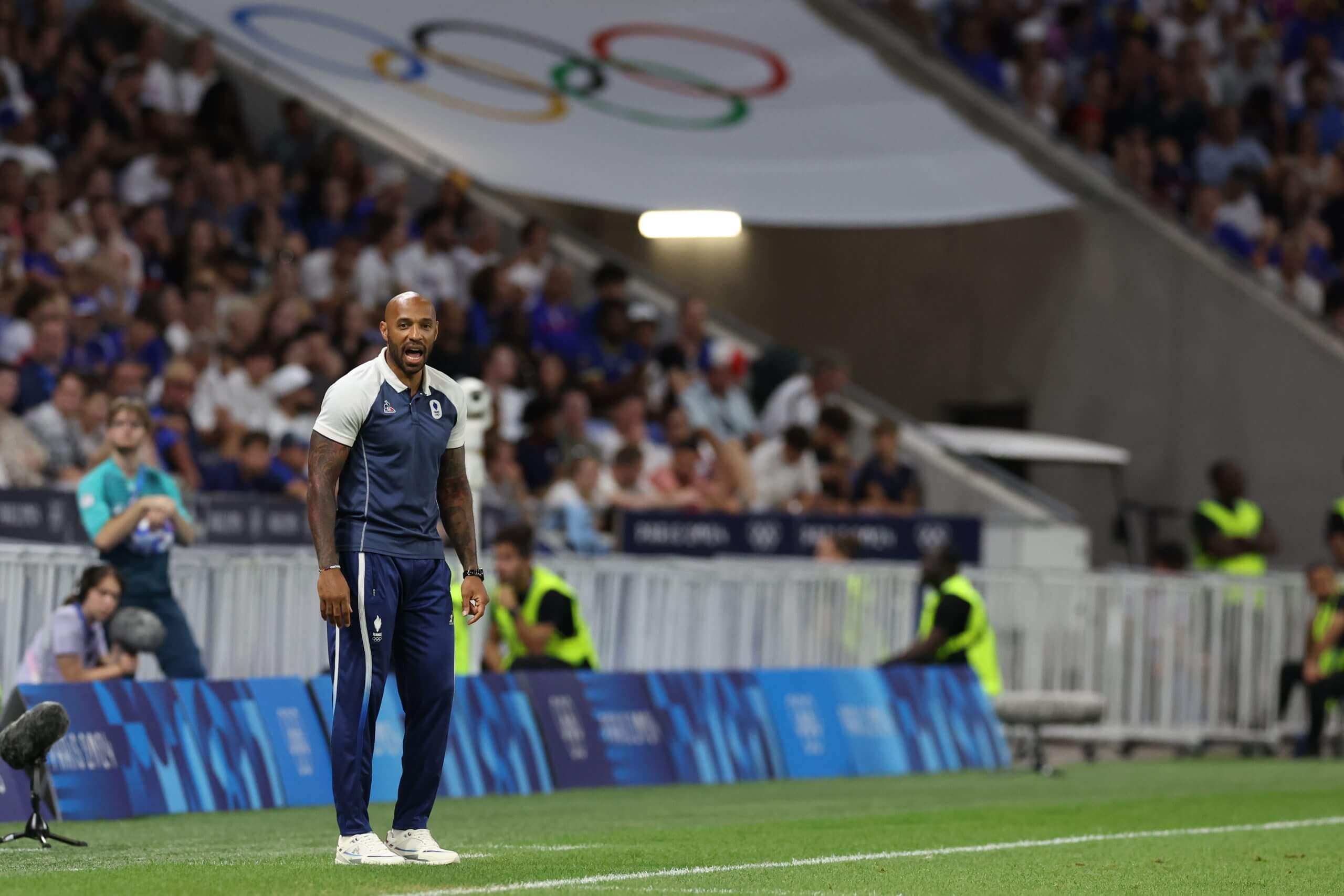 A football coach on the sideline at an Olympic football game