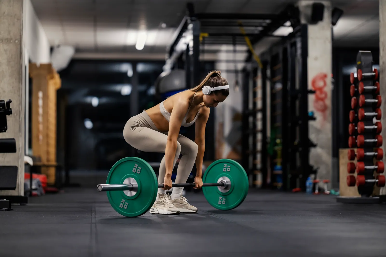 A woman lifts a weight at a gym.