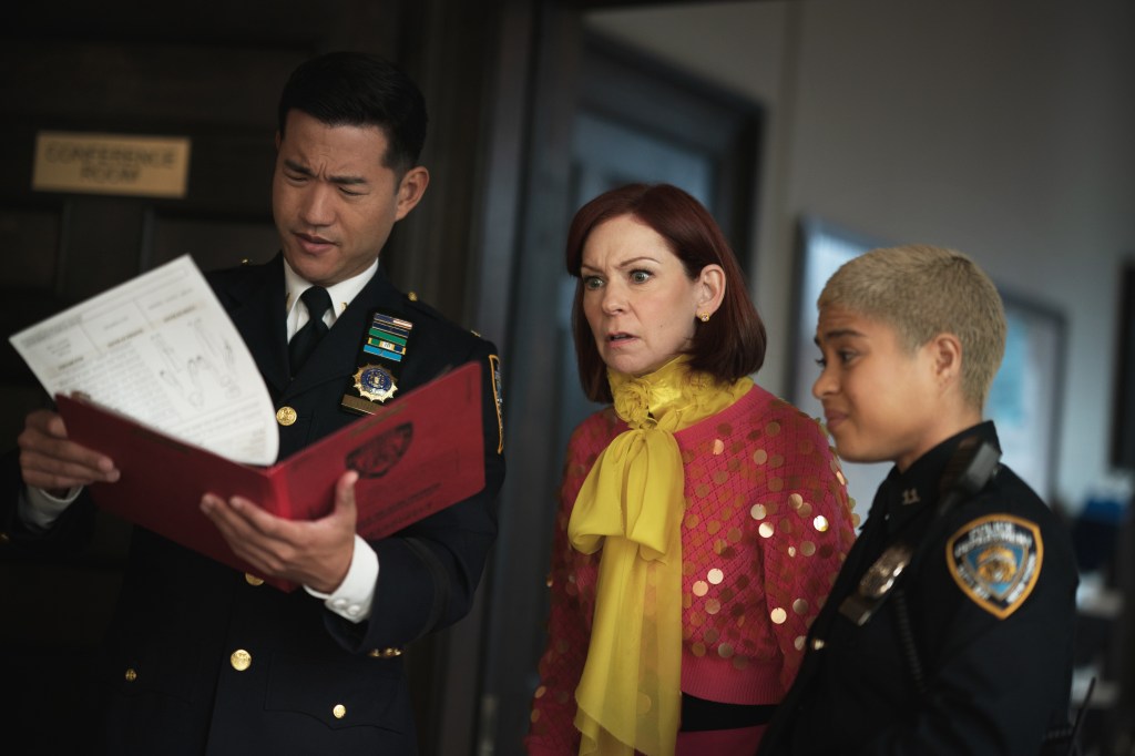 Three people, two in police uniforms, looking at a document held by the man in the center.