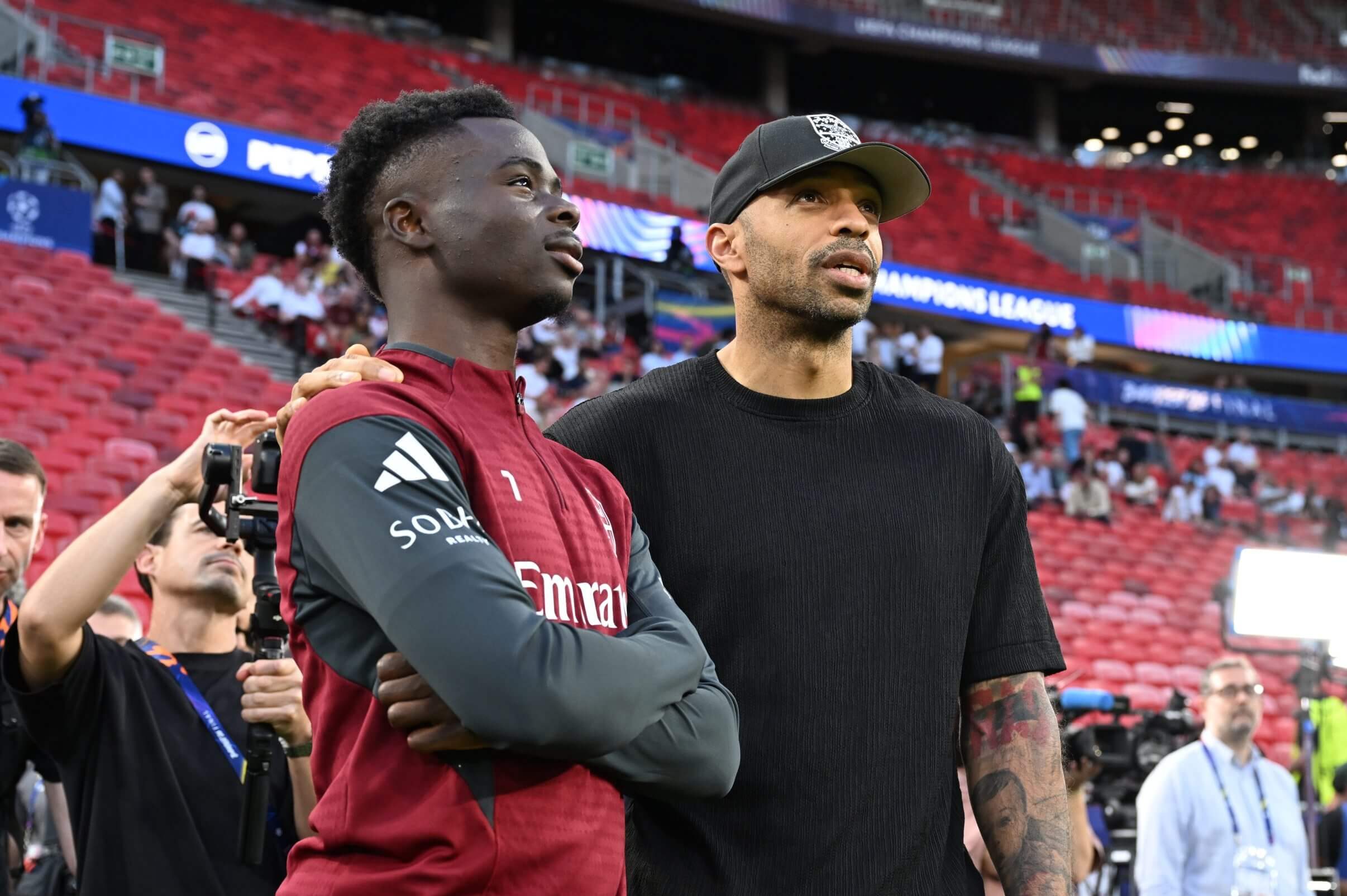 Thierry Henry and Bukayo Saka stand next to each other