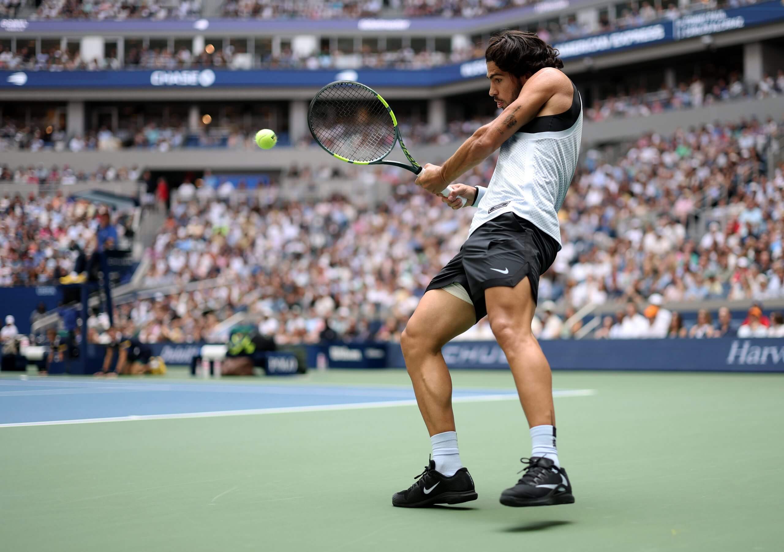 Carlos Alcaraz scrunching up for a tight backhand return.