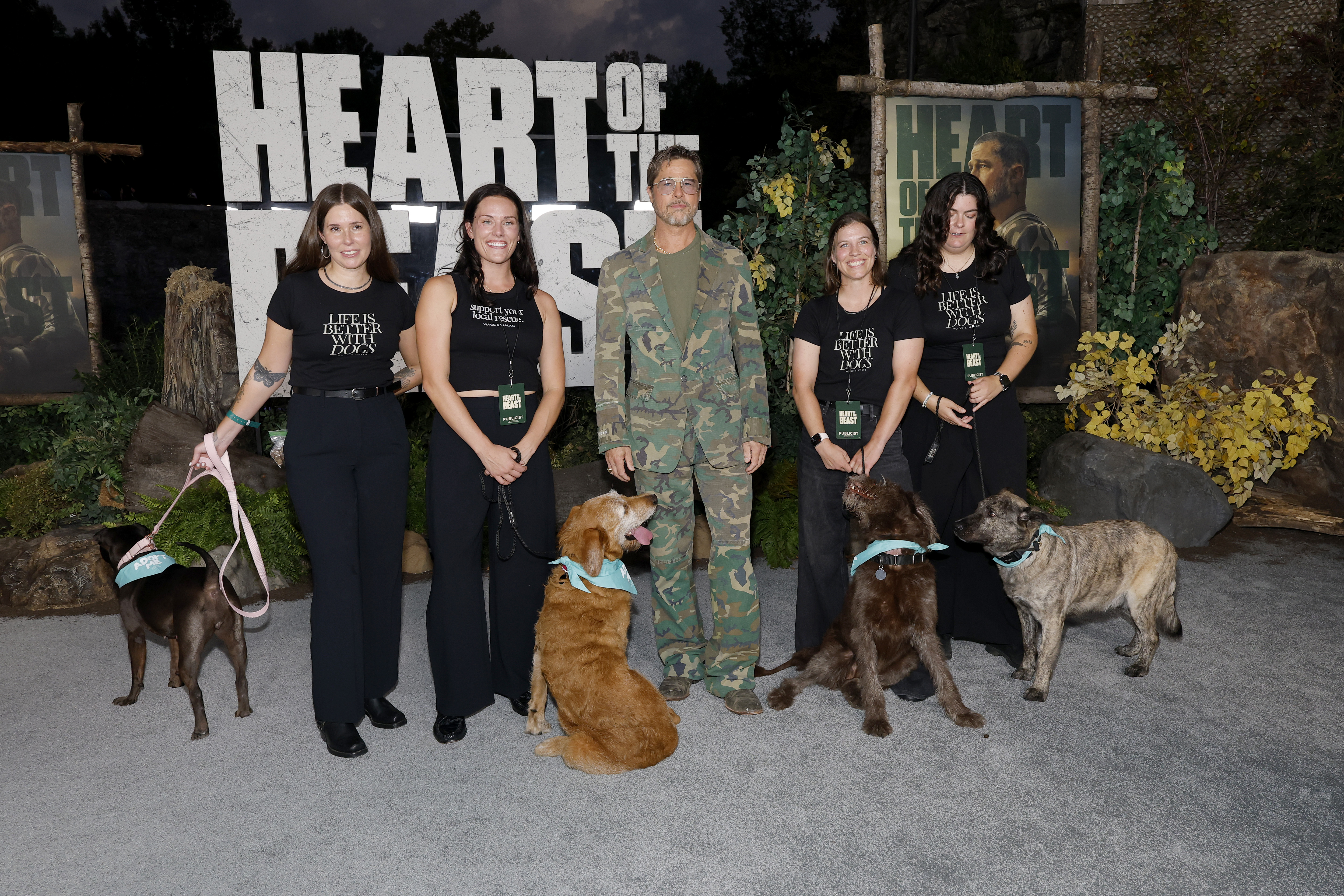 Brad Pitt, four women, and four dogs pose at the "Heart Of The Beast" global premiere.