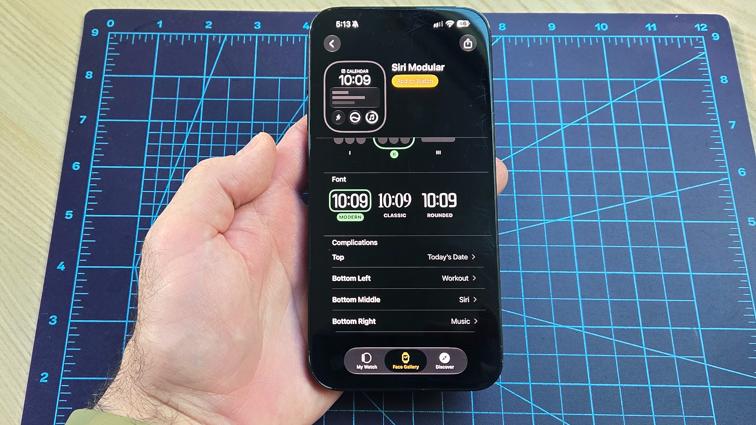 Close-up of an iPhone 16 Plus showing how to add the new step count widget to your Apple Watch's watch face