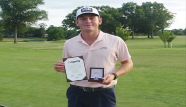 Golfer on a green course holding a certificate and a medal box, celebrating an achievement.