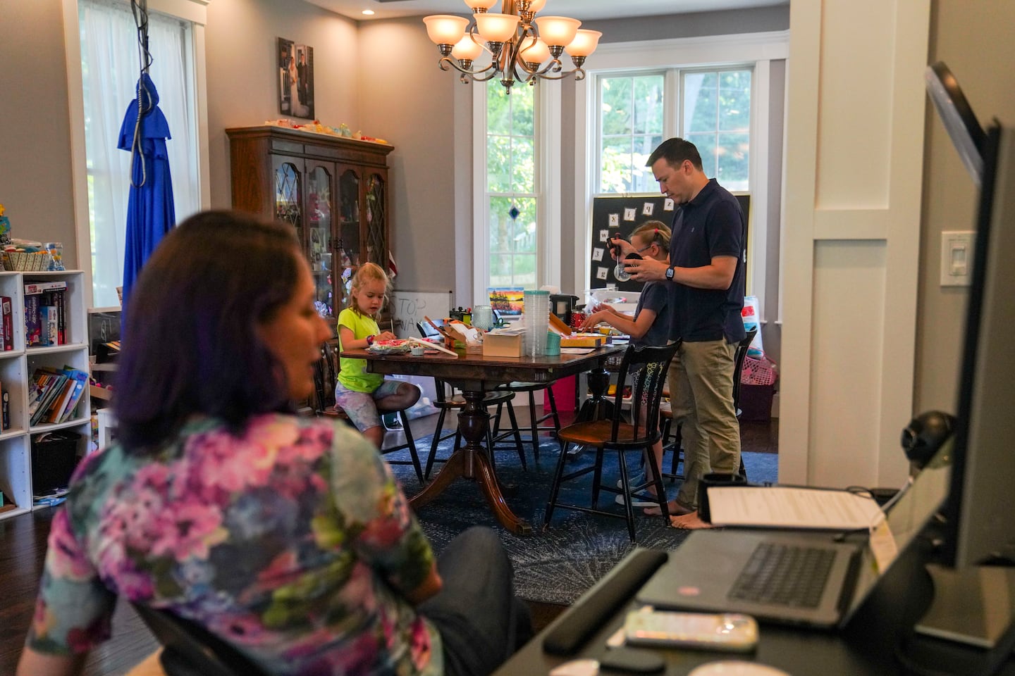 Olivia (left) and big sister Fiona made crafts with their father, as their mom looked at a family medications chart on her laptop.