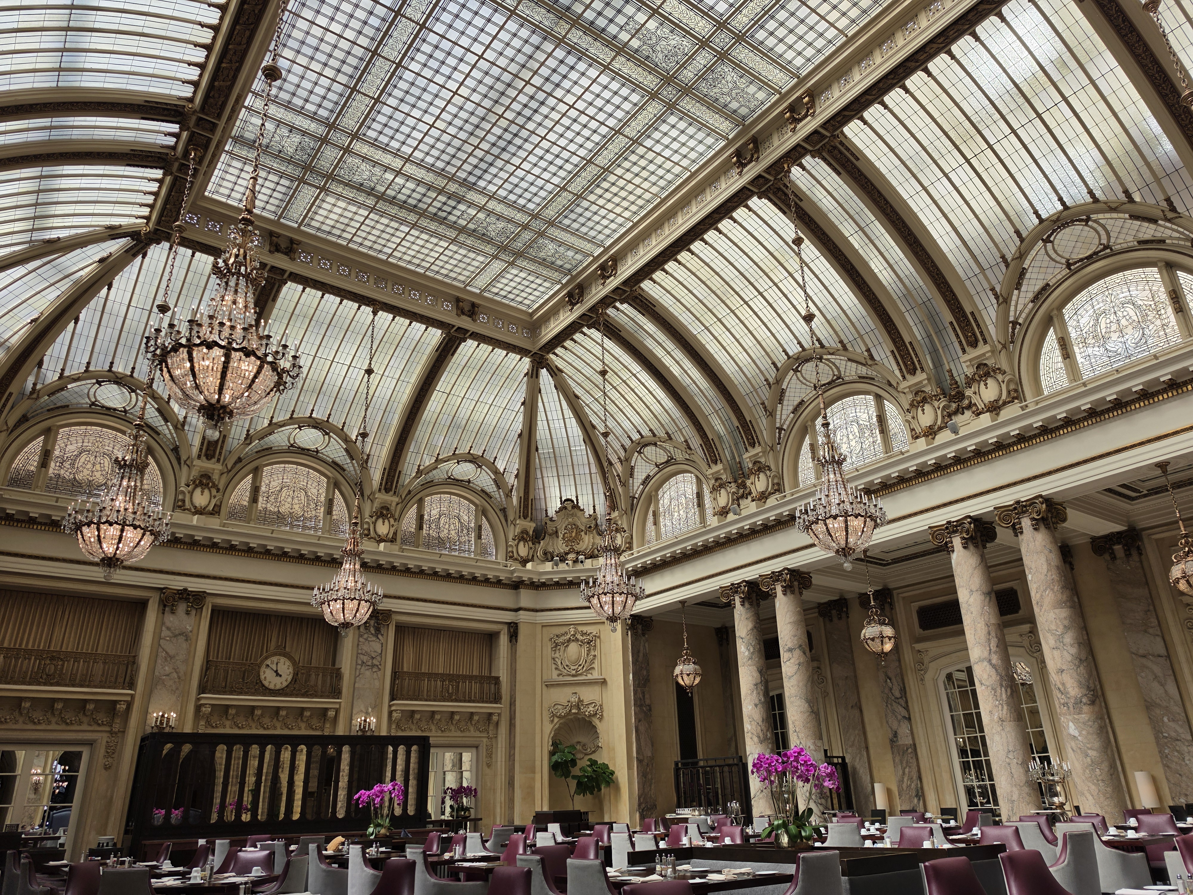 A hotel lobby with a glass ceiling and chandeliers