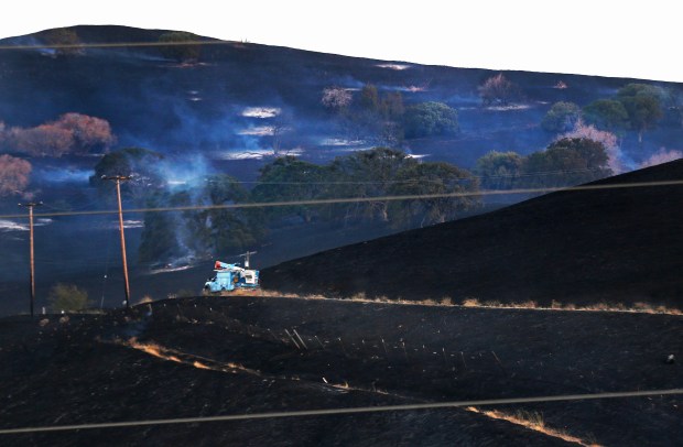 A PG&E utility truck rides between burned hills as firefighters from multiple agencies extinguish the Hollow Fire near Tesla Road southeast of Livermore on Thursday, July 16, 2020.  (Ray Chavez/Bay Area News Group)