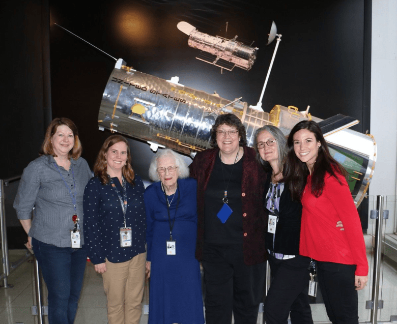 Dr. Nancy Grace Roman, center, NASA’s first chief astronomer and the namesake of the Nancy Grace Roman Space Telescope, poses with members of the Hubble team in front of a Hubble Space Telescope model at NASA’s Goddard Space Flight Center in Greenbelt. Photo courtesy of NASA. | Image credit: NASA