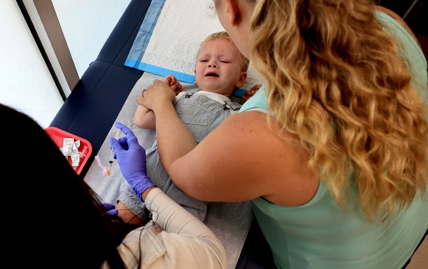 Sarah White comforts her 20 month-old son Landden as he receives the MMR vaccine for measles, mumps and rubella from Maribel Gonzalez, a medical assistant team leader at Santa Rosa Community Health, Tuesday, July 28, 2026, in Santa Rosa. (Kent Porter / The Press Democrat)