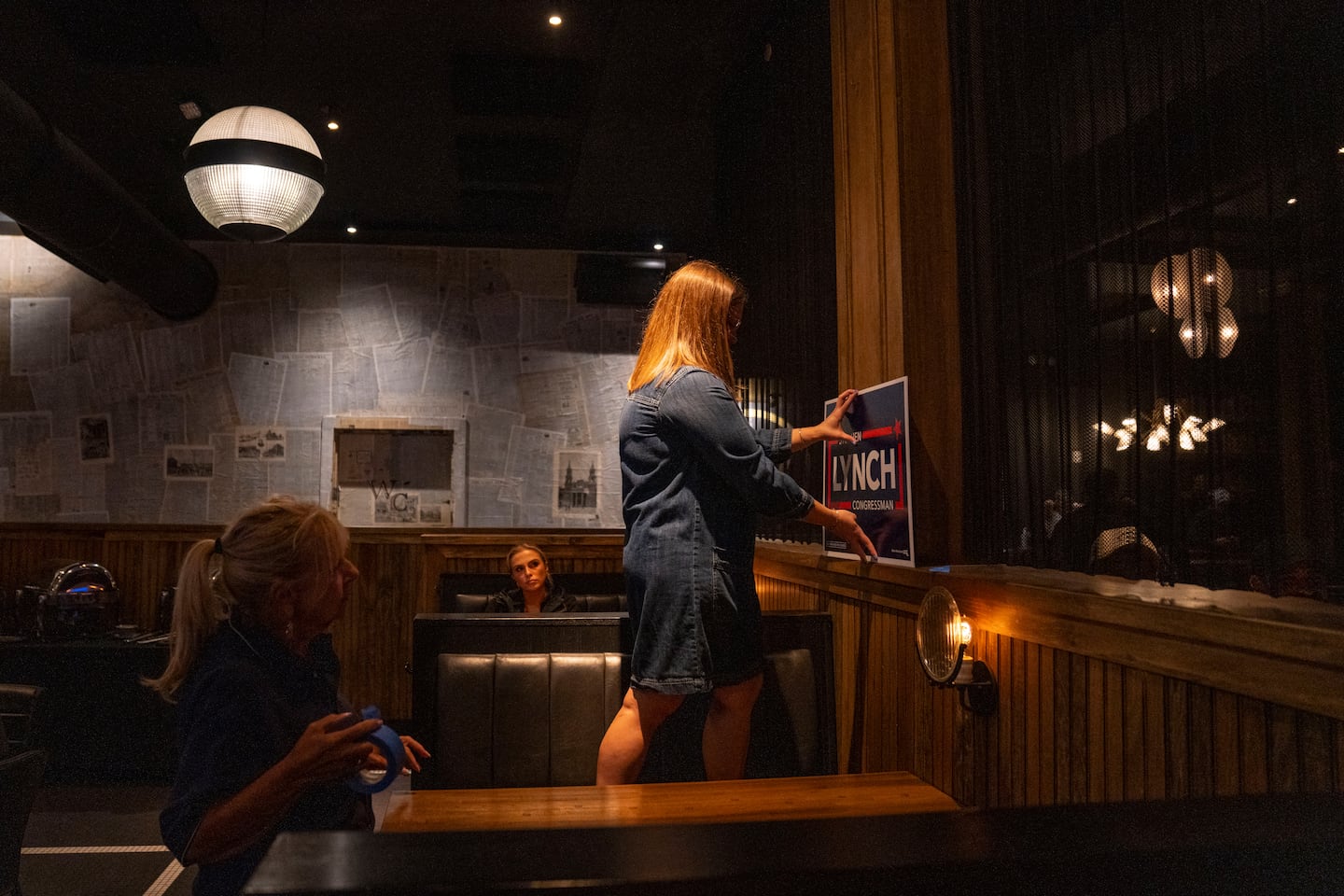 Relatives of candidate in the Democratic primary, Stephen F. Lynch, Karen Oleari, and Kait Couturier put up plaques in preparation for his election night watch party on Election Day.