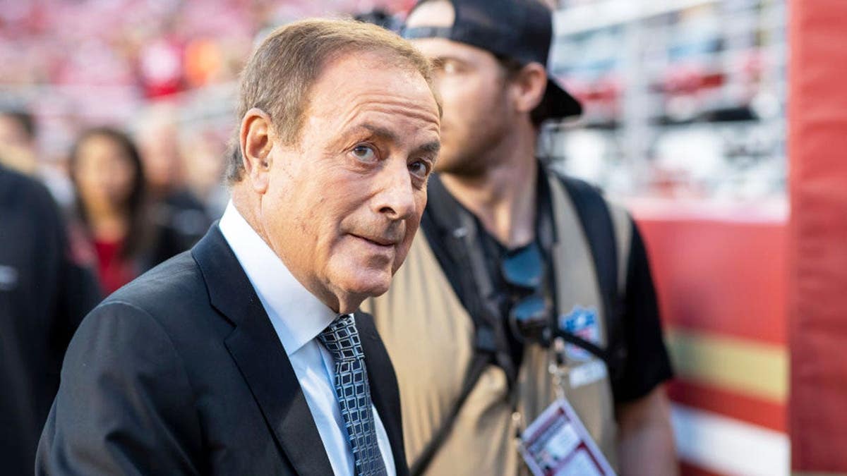 Al Michaels stands on the field during an NFL game between the San Francisco 49ers and Green Bay Packers.