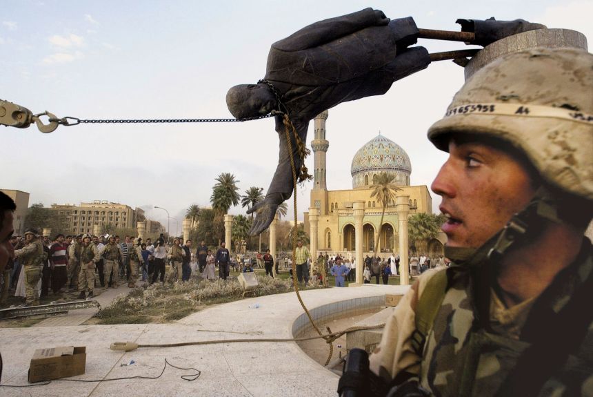Iraqi civilians and US soldiers pull down a statue of Saddam Hussein in downtown Baghdad on April 9, 2003.