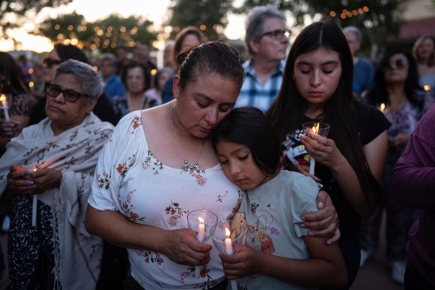 Judith Cabrera and her daughter, April, attend a September 17 vigil for the victims of the bus collision and helicopter crash in the Chatsworth neighborhood of Los Angeles.