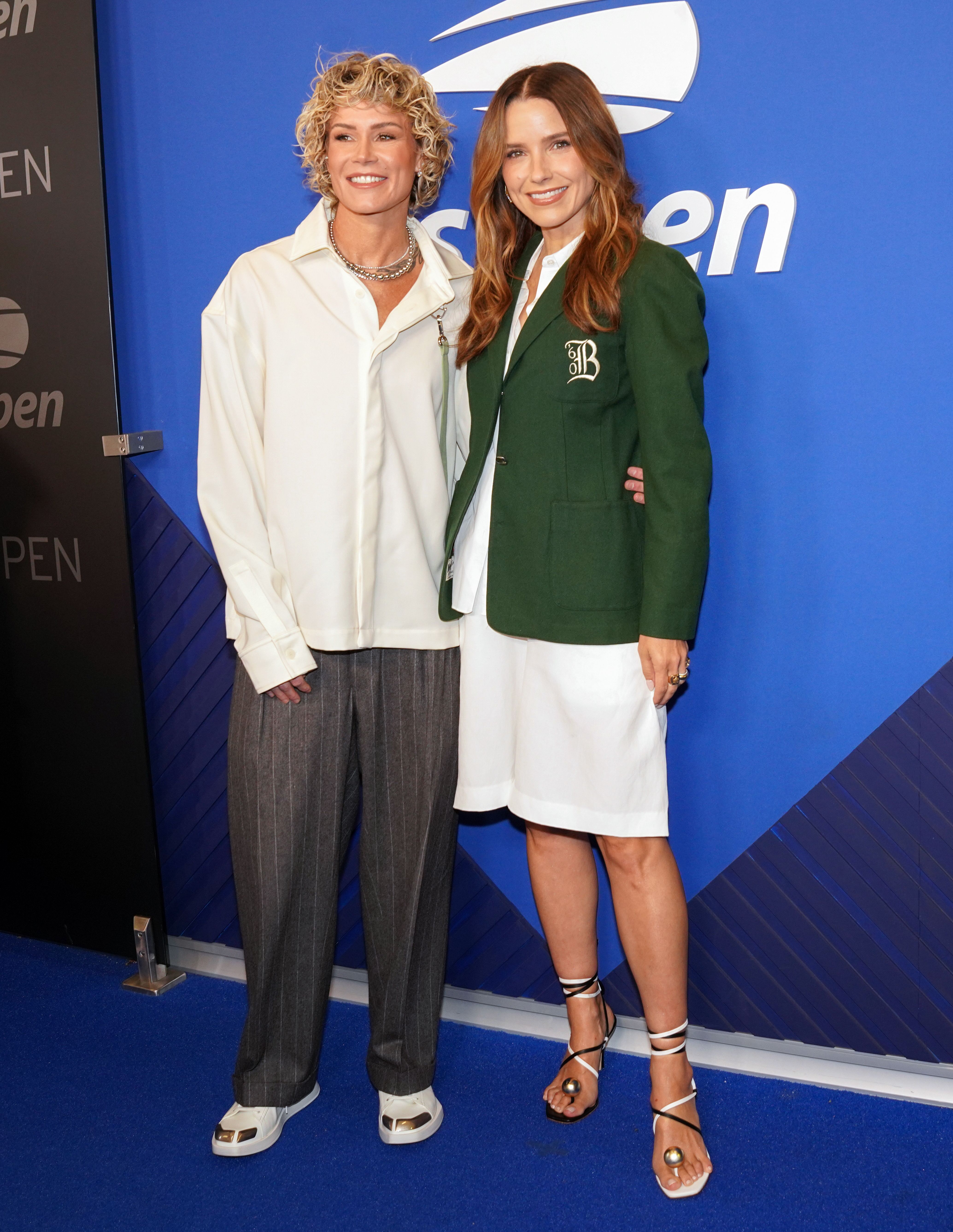 Ashlyn Harris and Sophia Bush pose together on the blue carpet at the US Open Men's Finals.