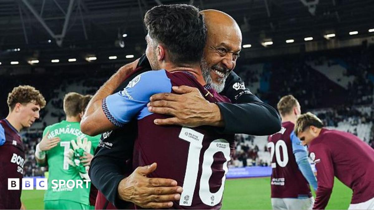 West Ham United coach Nuno Espirito Santo smiles broadly as he embraces player Manor Solomon, who is dressed in the club's claret and blue kit with the number 10 on the back. Other West Ham players embrace and walk around in the background.