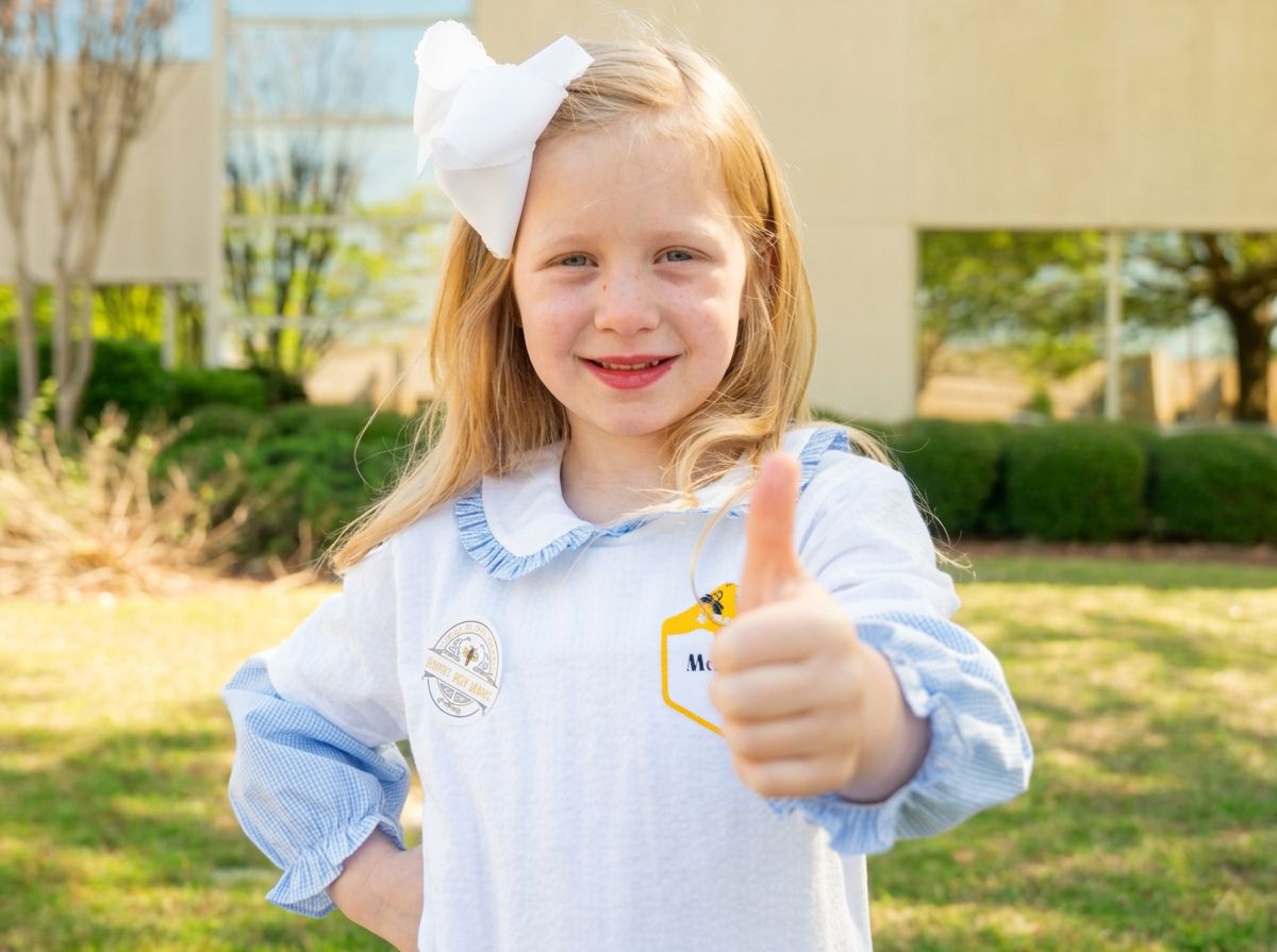 young girl with thumbs up outside of a credit union