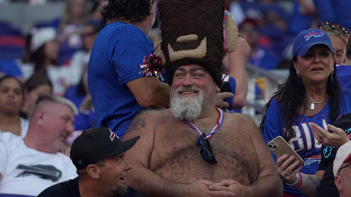 A fan wearing a Buffalo hat at Highmark Stadium during a Bills preseason game.