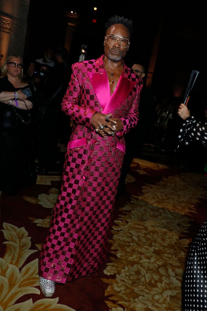 Billy Porter in a long, checkered fuchsia and deep pink suit at the Christian Siriano show.